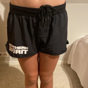 Svarta träningsshorts från Northern Spirit - Säljer ett par svarta träningsshorts från Northern Spirit i storlek XS. De är gjorda av 95% polyester och 5% elastan, vilket gör dem superbekväma och flexibla. Perfekta för gymmet eller löprundan! De har en elastisk midja med snörning för bästa passform.💫