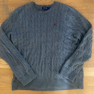 Ralph lauren tjocktröja - En fin, grå Ralph lauren tjocktröja. Plagget är förstås äkta och har inga hål eller skavanker. Storlek L men passar även M väldigt bra. DM:a vid frågor eller funderingar. 