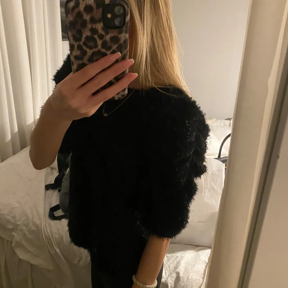 Säljer en superfin svart tröja med glittriga detaljer. Den har en fluffig textur och korta ärmar, perfekt för en utekväll eller fest. Tröjan är i mycket bra skick och ger en lyxig känsla. Passar perfekt till både jeans och kjol! Helt ny med prislapp kvar så skriv om ni vill ha bild bevis då jag glömde fota💕. Neuletakit & Villapaidat.