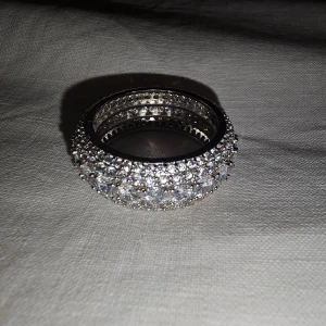 Högkvalitativ Ring från Streetice - Högkvalitativ Ring inköpt från Streetice, ungefär storlek 12. Stainless steel med 925 silver på topplagret. Fina glittrande stenar hela vägen runt ringen i olika storlekar. Inköpspris: 500kr (utan att räkna med frakt). 