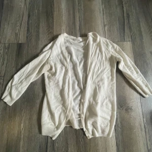 vit kofta - Säljer en mysig vit kofta i bra skick. Den har en enkel design med knappar framtill och trekvartsärmar. Perfekt för lager-på-lager under höst och vår. Passar till både vardag och lite finare tillfällen.