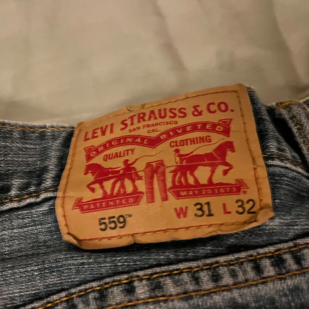 Säljer ett par klassiska Levi's 559 jeans i blå denim. De har en straight passform och är i bra skick. Perfekta för både vardag och avslappnade tillfällen. Jeansens tidlösa design gör dem till ett måste i garderoben!. Jeans & Byxor.