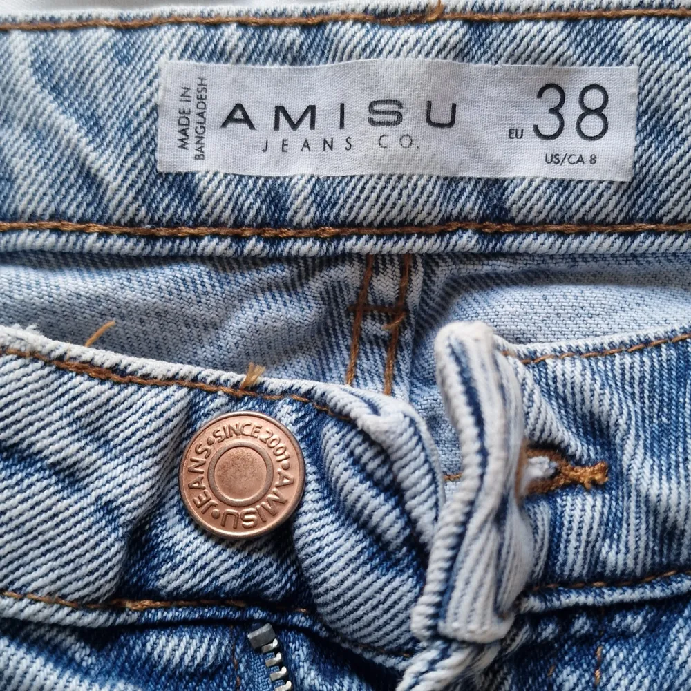 Säljer ett par snygga blå jeans från Amisu i storlek 38. De har en klassisk design med dragkedja och knapp framtill. Perfekta för vardagsbruk och kan enkelt matchas med olika toppar. Passar både till sneakers och klackar!. Jeans & Byxor.