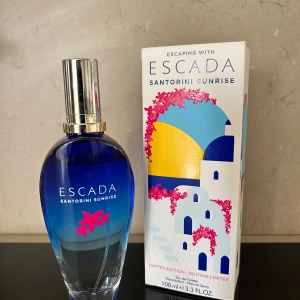 Parfym Escada Santorini Sunrise - Säljer en Escada Santorini Sunrise då den inte används. Toppnoterna är Sorbet, Mandarin and Bergamot; mellannöter är Bougainvillea, Jasmine and Pink Pepper; basnot är jordiga noter. 