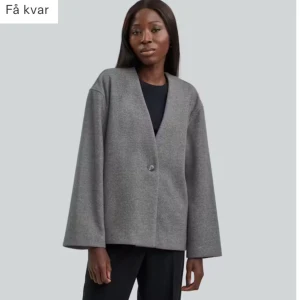 Grå kortkappa  - Snygg och stilren grå kappa med en enkel knapp framtill. Ganska tunn så passar både som kappa och kavaj. Ny med prislapp kvar, storlek Xs. Passar xs-m beroende på hur man vill att den ska sitta. Modellen har storlek s