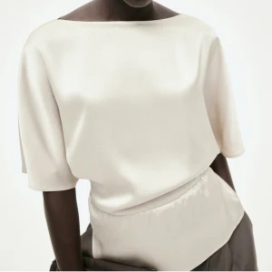 Krämvit blus med korta ärmar - Elegant krämvit blus med korta ärmar och en lös passform. Perfekt för både vardag och festliga tillfällen. Den har en enkel och stilren design som gör den lätt att matcha med olika outfits. Helt oanvänd med lappar kvar, säljer då jag beställde i somras men inte kommit till användning och försent för en retur. Den är endast testad annars är den helt som ny. Slutsåld i alla storlekar och kommer nog inte tillbaka i lager🩷