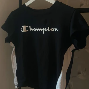 Champion tshirt - Tshirt från champion, svart med vita ränder på sidan. Det är en storlek M, men skulle säga att den är mer som S/M