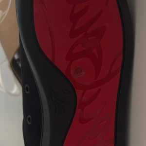 Svarta sneakers från Christian Louboutin - Säljer ett par svarta sneakers från Christian Louboutin i mycket bra skick. Skorna har en ikonisk röd sula. Perfekta för både vardag och fest! Kan gå ner i pris vid snabb affär
