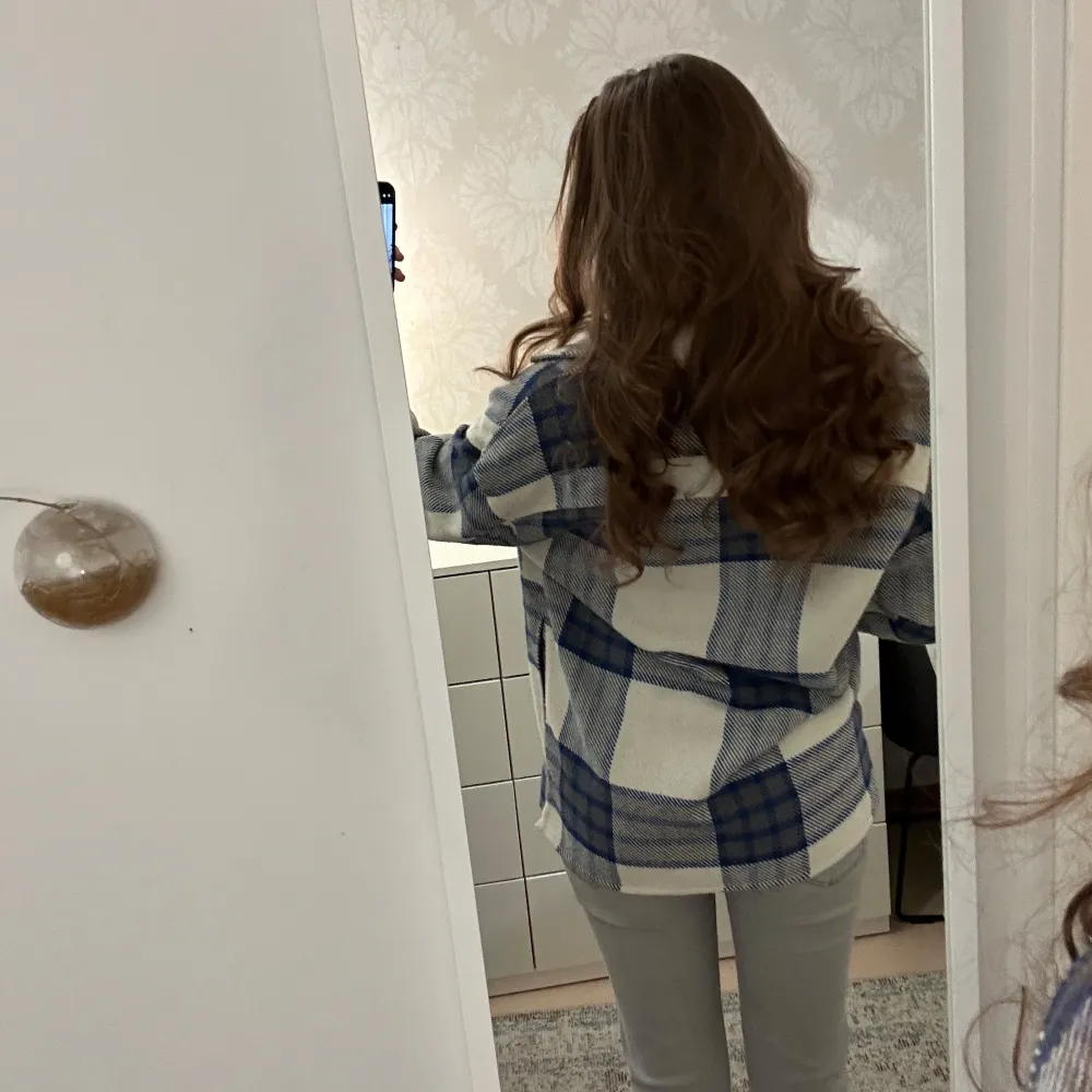 Säljer en superfin blå och vit rutig overshirt. Perfekt för höst och vår! Den har en avslappnad passform och är gjord i ett mjukt material. Skjortan har långa ärmar och knappar framtill. Perfekt att bära över en t-shirt för en casual look. 🧥💙. Paidat.