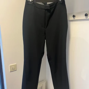 Kostymbyxor från NA-KD - Använda fåtal gånger! Sitter figurformat, något lösare längre ner. Har en slits på båda benen. Skönt material. Väldigt lite nopprig på bakfickor men inte alls så farligt. Är storlek 40 men rekommenderar dem till storlek 38 då jag har 40 och de sitter för tight.