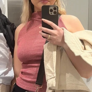 Glittrig rosa topp från Zara - Säljer en superfin rosa ribbad topp från Zara. Perfekt för både vardag och fest! Toppen är i mycket bra skick och har en snygg glittrig effekt i tyget.