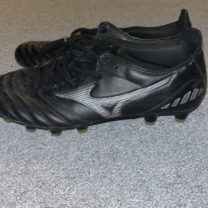 Svarta fotbollsskor från Morelia Neo - Säljer ett par svarta fotbollsskor från Morelia Neo i bra skick. Skorna har snörning och är tillverkade i skinn för bästa komfort och hållbarhet. Perfekta för fotbollsträning och matcher. Sulan har flera dobbar för bra grepp på planen.