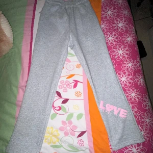 Mjukisbyxor  - Säljer ett par mjukisbyxor i grå + rosa tryck, storlek XS!! Helt oanvända hämtade ut paketet 6/11-2024, problemet var att de var lite för små.  Byxorna är varma och fodrade vilket är extra skönt till kommande kyliga tider. Pris 500kr, går inte under då de är helt oanvända och i nyskick. Kan mötas upp i Jönköping!🩷 