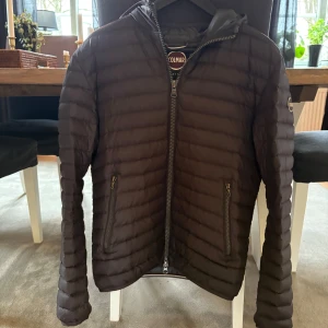 Svart dunjacka från Colmar - Säljer en snygg svart dunjacka från Colmar i mycket bra skick. Jackan har en dragkedja framtill och två praktiska fickor med dragkedjor. Perfekt för kyliga dagar med sin quiltade design och huva. Passar både till vardags och lite finare tillfällen. 🖤