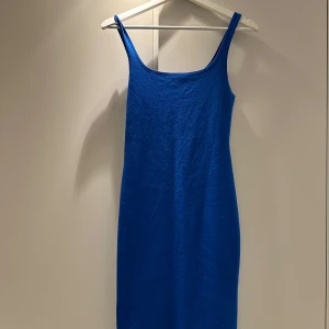 Blå klänning från Zara - Snygg blå klänning från Zara i ett mjukt och stretchigt material. Perfekt för både vardag och fest! Den har en enkel och stilren design med smala axelband och en kroppsnära passform. Klänningen är i mycket bra skick och redo att bäras till alla tillfällen.