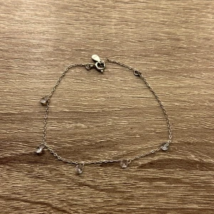 Silverarmband med små pärlor - Ett elegant och enkelt silverarmband med små, klara pärlor som hänger längs kedjan. Perfekt för både vardag och festliga tillfällen. Armbandet är lätt och bekvämt att bära, och ger en subtil glans till din outfit. Äkta silver!