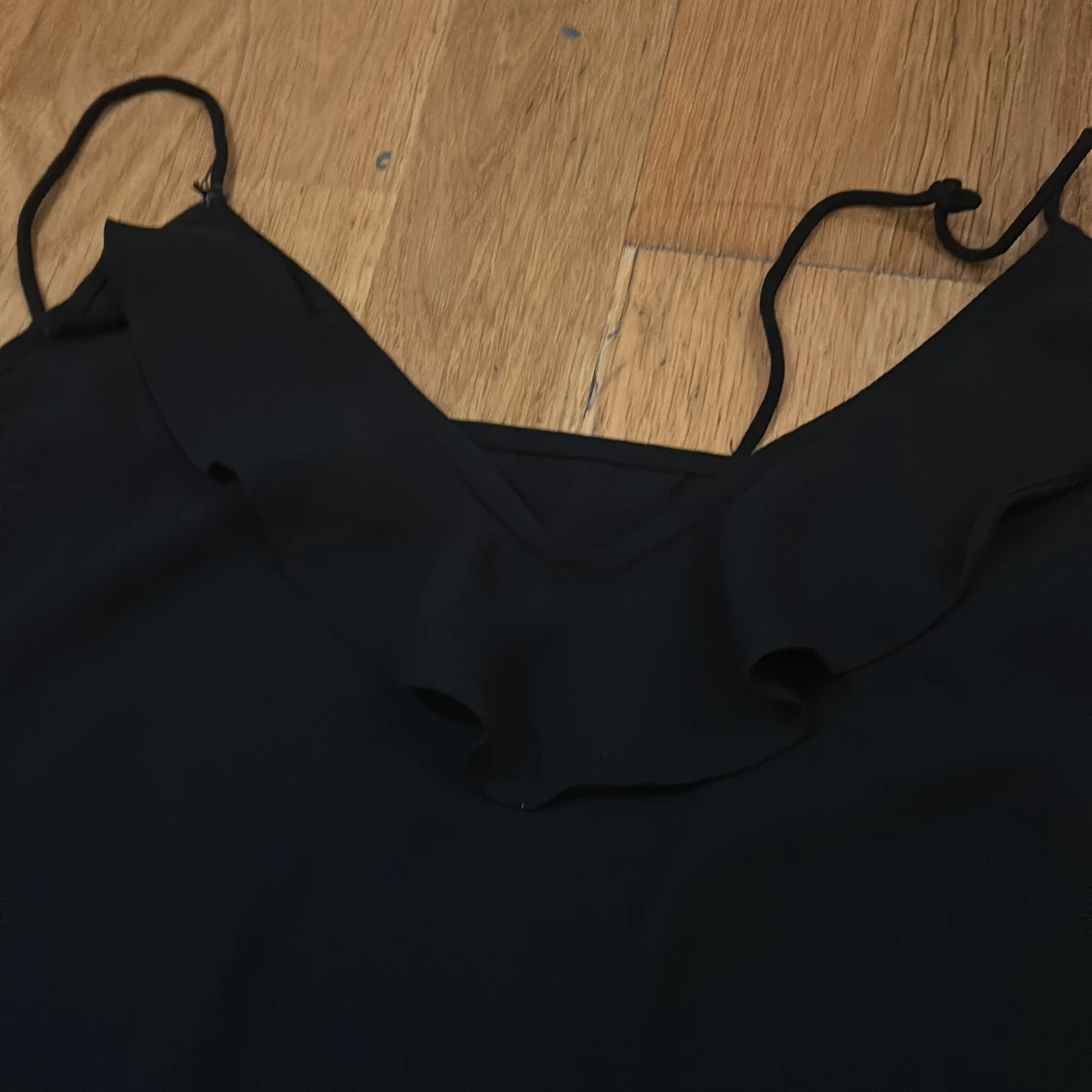 Svart ärmlös topp med volangdetalj från Gina Tricot - 90