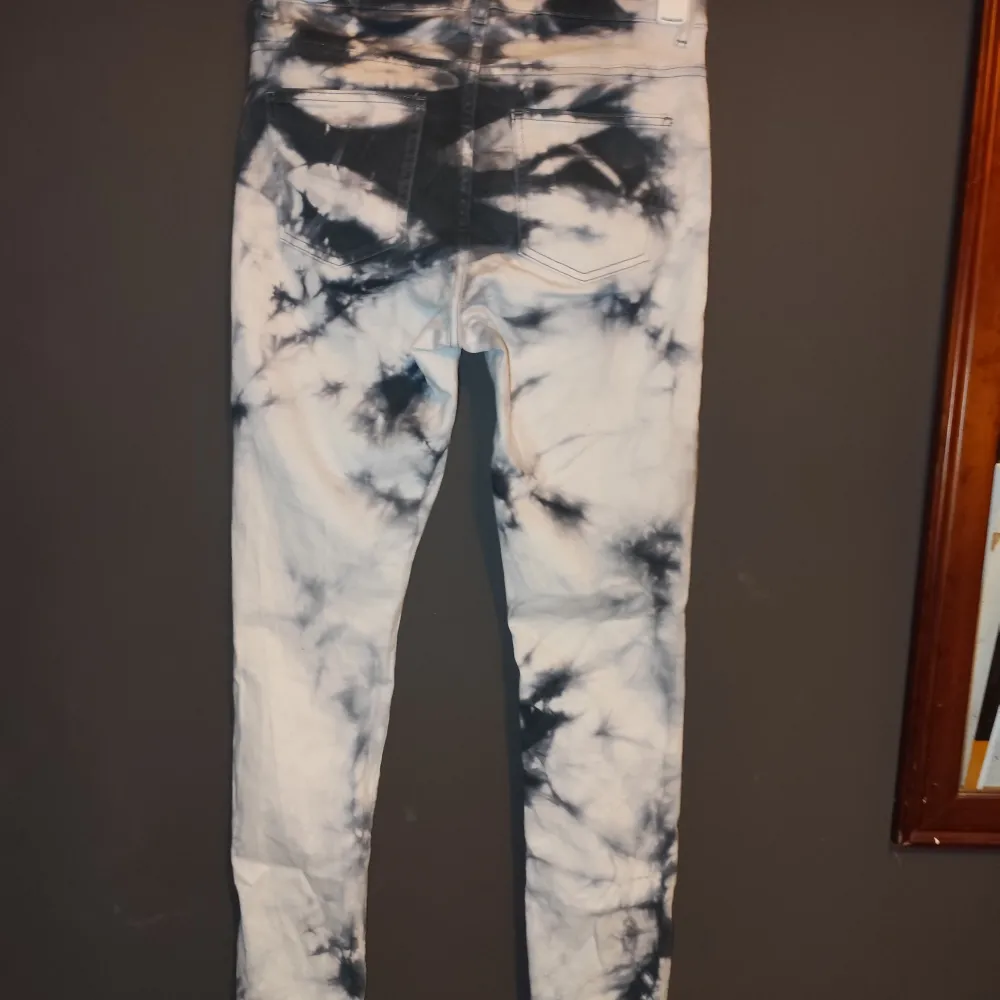 Säljer ett par snygga tie-dye jeans från Monki i storlek M. De har en cool blå och vit mönster och är i mycket bra skick. Perfekta för att ge din outfit en unik touch! 💙🤍. Jeans & Byxor.