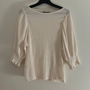 Vit blus med trekvartsärm - Säljer en superfin cremevit blus med trekvartsärm. Använd fåtal gånger och är i mycket bra skick. Perfekt för både vardag och fest!