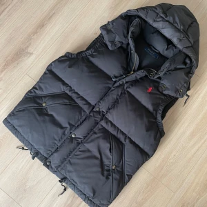 Ralph Lauren väst - Säljer en snygg svart dunväst från Polo Ralph Lauren. Den är i storlek S. Hör av er om ni har frågor!
