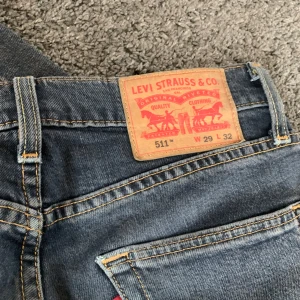 Levi's 511 jeans - Säljer ett par snygga Levi's 511 jeans i blå denim. De har en slim passform och är i mycket bra skick. Perfekta för både vardag och speciella tillfällen!