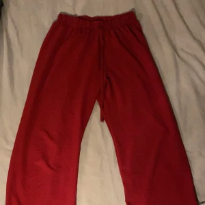 Röda mjukisbyxor - Säljer ett par bekväma röda mjukisbyxor med elastisk midja och dragsko. Perfekta för en avslappnad dag hemma eller på språng.