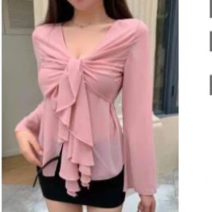 Rosa blus med volangdetaljer - Elegant rosa blus med långa ärmar och volangdetaljer framtill. Blusen har en v-ringad design. Hittar ej denna på SHEIN så tror de tagit bort den