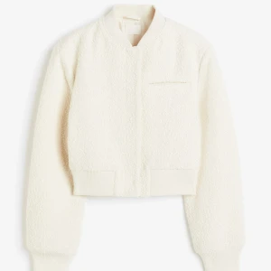 Vit teddyjacka med knappar - Säljer en stilren vit teddyjacka med knappar och ribbade muddar. Jackan är i väldigt bra skick då den är använd 2 gånger