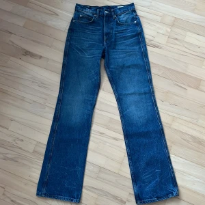 Blå bootcut jeans från Zara - Snygga blå bootcut jeans från Zara med klassisk femficksdesign. De har en högmidjad passform och är perfekta för en avslappnad stil. Tillverkade i ett slitstarkt denimtyg.