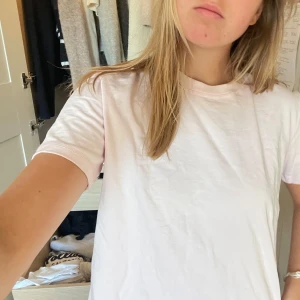 Vit t-shirt - Säljer en enkel och stilren vit t-shirt med korta ärmar. Perfekt basplagg för alla tillfällen. Passar bra till både jeans och kjol.