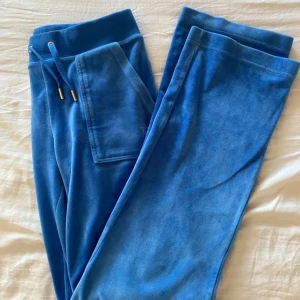 Blå mjukisbyxor från Juicy Couture - Fina Juicy Couture - mjukisar i färgen Regatta, strl XS men funkar på mig som vanligtvis har S. Jag skulle säga att de är i fint begagnat skick, lite noppror på midjebandet (bild 2) men inget som syns vid användning! Skriv för fler bilder!☺️