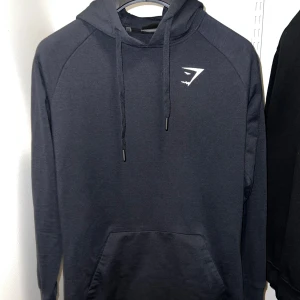 Svart Ark hoodie från Gymshark - Säljer en stilren svart hoodie från Gymshark med justerbar huva och känguruficka. Storlek S.