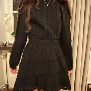 Svart klänning från Zara - Snygg svart klänning från Zara med broderade detaljer och volanger. Klänningen har aldrig använts och har långa ärmar och en kort längd, perfekt som fin klänning och till sommaren! Nypris 500kr❣️