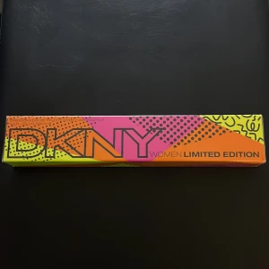 DKNY Women Limited Edition Parfym - Snygg och färgglad förpackning av DKNY Women Limited Edition parfym. Förpackningen har en mix av neonfärger som rosa, orange och gul med ett modernt grafiskt mönster. Perfekt för den som vill ha något unikt och iögonfallande. 