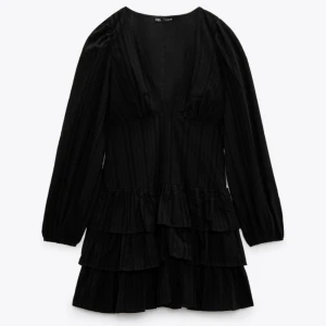 Svart klänning - Svart långärmad klänning från Zara med volanger. Storlek S. Använd fåtal gånger. 