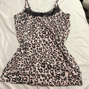 Leopardmönstrad topp från New Woman - Snygg leopardmönstrad topp från New Woman i storlek S. Toppen har smala axelband och en fin spetsdetalj vid halsringningen. Perfekt för fest