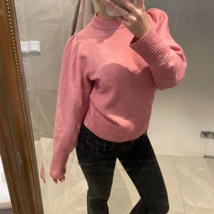 Rosa stickad tröja - Säljer en söt rosa stickad tröja med långa ärmar och ribbade muddar. Perfekt för kyligare dagar och ger en mysig känsla. Passar bra till jeans eller kjol för en avslappnad look.