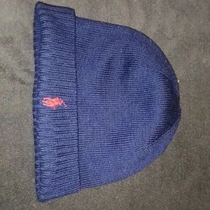Mörkblå mössa från Polo Ralph Lauren - Mörkblå mössa från Polo Ralph Lauren i merinoull.