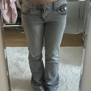 Grå bootcut jeans - Snygga grå bootcut jeans med låg midja och klassiska femficksdetaljer. Säljer pågrund av att dom är lite för långa! Jag är 163