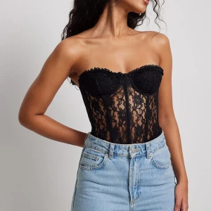 Spets topp - Säljer denna sjukt snygga korsetten. Endast andvönd några gånger men är i mycket bra skick! Den är från NA-KD men det är helt slutsåld i alla storlekar.