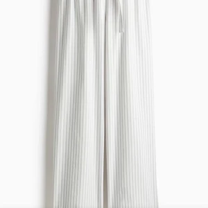 Randiga pyjamasbyxor  - Snygga och bekväma randiga pyjamasbyxor i vitt och grått med elastisk midja och dragsko. Perfekta för en avslappnad stil. Jättesköna, helt nya prislapp kvar. 