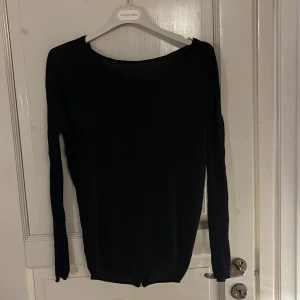 Svart kofta från Wera Stockholm - Snygg svart tröja i viskos, bomull, ull och angora, från Wera Stockholm med dragkedja baktill. Perfekt för lager-på-lager och passar till många olika outfits. Koftan har långa ärmar och en stilren design.