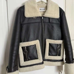 Svart skinnjacka med foder från NA-KD - Snygg svart skinnjacka från NA-KD med mjukt vitt foder. I princip nyskick, knappt använd. Nypris 999 kr😊