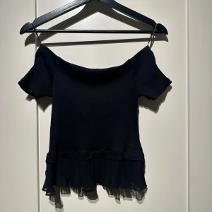 Svart offshoulder topp från Zara - Svart offshoulder topp från Zara med volang nertill. Stl S, mycket fint skick.