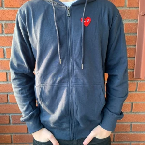 CDG hoodie - Säljer en mörkblå zip-up hoodie av märket CDG/Comme Des Garcons. Den är i nytt skick med lapparna på och i superbra kvalitet. Personen på bilden är ca 180cm/70kg