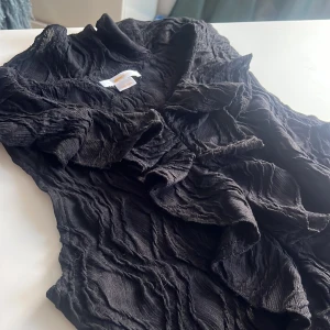 Svart ärmlös topp från Gina Tricot - Säljer en svart ärmlös topp från Gina Tricot med volangdetaljer framtill. Perfekt för att lägga till en touch av elegans till din outfit.❤️ Pris kan diskuteras skriv gärna om du är lite sugen på att köpa den🎀