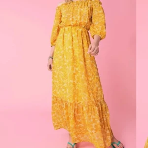Gul blommig långklänning - Charmig gul långklänning med blommigt mönster och offshoulder-design. Klänningen har trekvartsärmar och volangdetaljer vid fållen. Perfekt för sommarens festligheter!