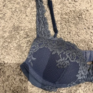 Mörkblå spets-bh - Snygg mörkblå bh med spetsdetaljer från Intimissimi. Den har justerbara axelband och en klassisk knäppning bak. Passar till vardags eller speciella tillfällen. Använd ungefär 5 gånger. Tvättas såklart innan.