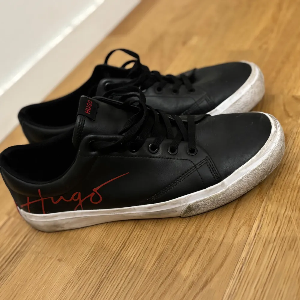 Säljer dessa prydliga HUGO sneakers i storlek 42. Använd ett fåtal gånger och är i mycket fint skick, skulle behöva tvätta sulan men annars toppenbra.. Kengät.