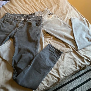 Replay - Säljer två par grå jeans från Replay i modellen Anbass. De är i bra skick och har en snygg, modern look. Perfekta för både vardag och fest! De har en normal passform och är tillverkade i ett bekvämt denimtyg.